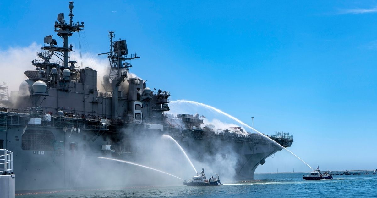 Police boats combat a fire aboard the amphibious assault ship USS Bonhomme Richard at Naval Base San Diego on July 12, 2020.