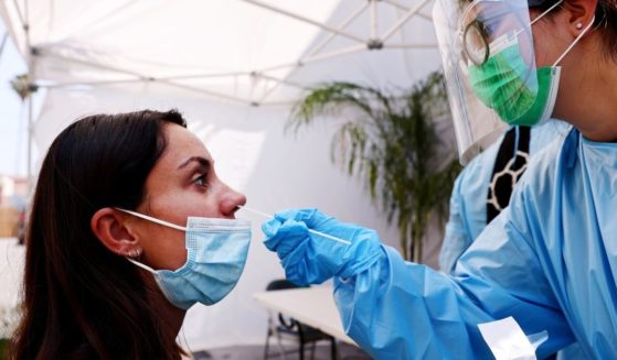 A nurse administers a COVID-19 test to a woman on July 14, 2021, in Los Angeles.