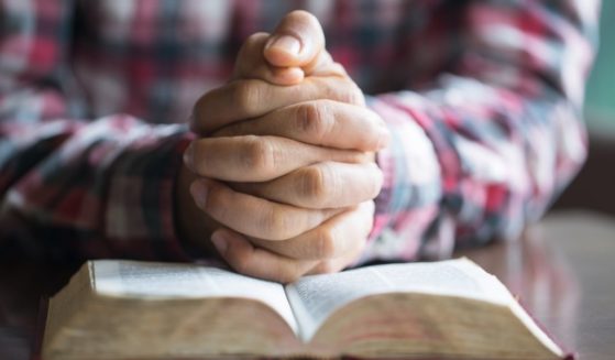 A man prays in this stock image.
