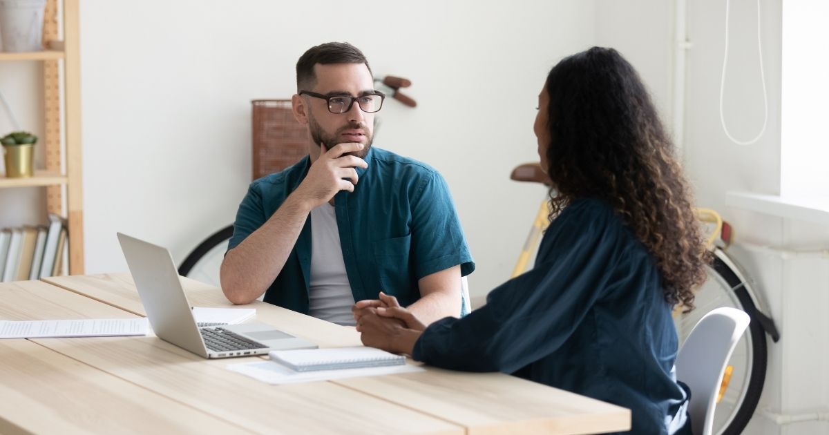 Two people are pictured having a conversation in the stock image above.