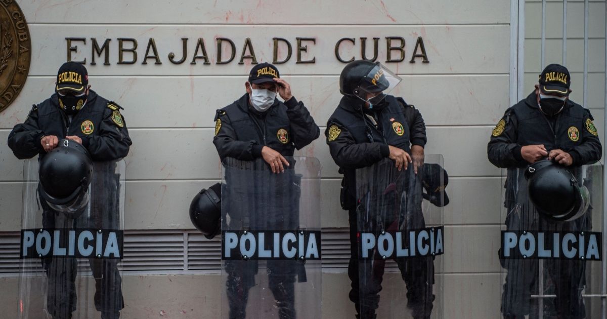 Police officers stand guard outside the Cuban Embassy during a demonstration of Cuban citizens residing in Peru against the Cuban government of President Miguel Díaz-Canel in Lima on Tuesday.