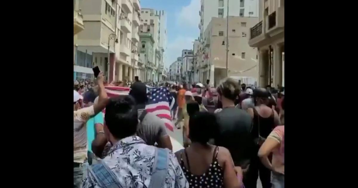 Cuban protesters wave an American Flag as they march against the communist regime in Havana.