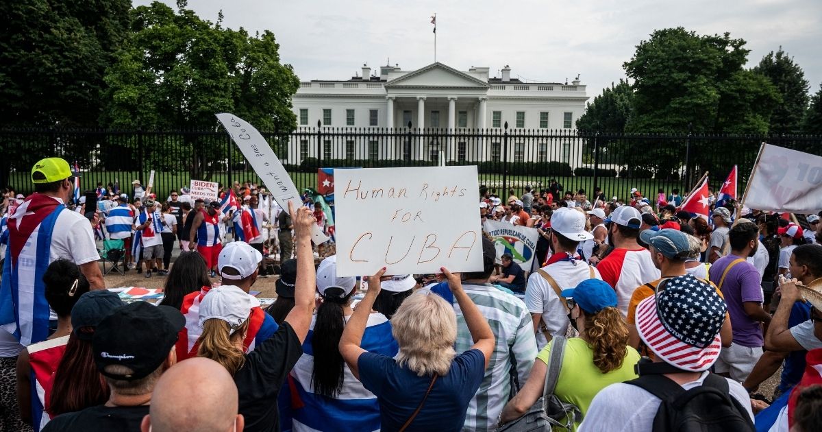 Protesters hold up signs during a demonstration in front of the White House on Sunday in Washington D.C.