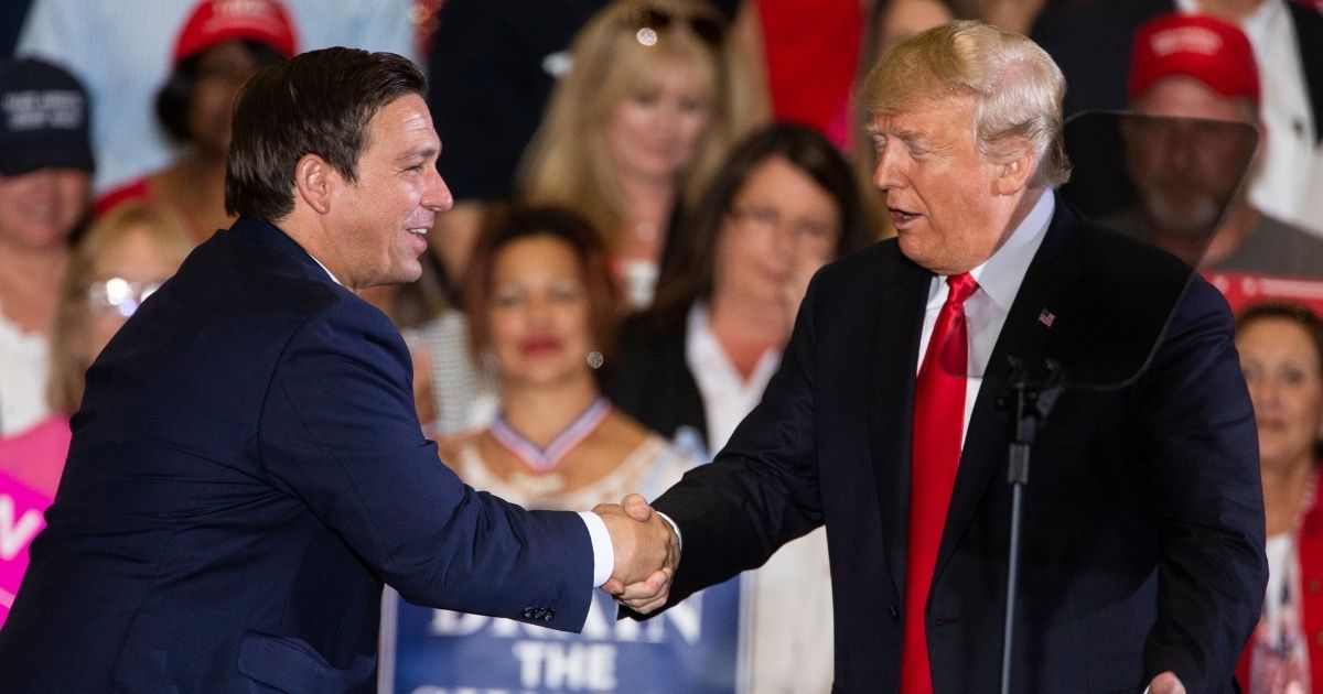 Then-President Donald Trump welcomes then-Florida gubernatorial candidate Ron DeSantis to the stage at a campaign rally at the Pensacola International Airport on Nov. 3, 2018, in Pensacola, Florida.