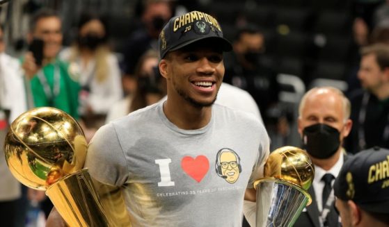 Giannis Antetokounmpo of the Milwaukee Bucks holds the Bill Russell NBA Finals MVP Award and the Larry O'Brien Championship Trophy after defeating the Phoenix Suns in Game 6 to win the 2021 NBA Finals at Fiserv Forum on Tuesday in Milwaukee.