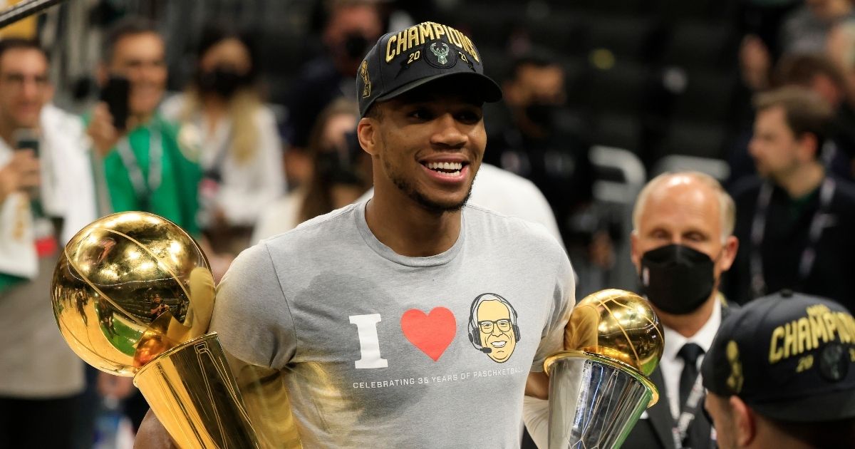 Giannis Antetokounmpo of the Milwaukee Bucks holds the Bill Russell NBA Finals MVP Award and the Larry O'Brien Championship Trophy after defeating the Phoenix Suns in Game 6 to win the 2021 NBA Finals at Fiserv Forum on Tuesday in Milwaukee.