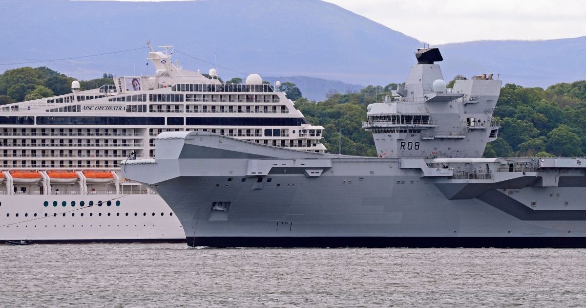 The Royal Navy aircraft carrier HMS Queen Elizabeth passes a cruise ship as she leaves the Forth Estuary following a period of planned maintenance in Rosyth Dockyard where she was built on May 23, 2019, in North Queensferry, Scotland.