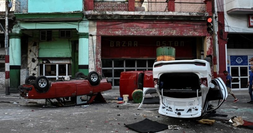 Police cars are seen overturned in the street in the framework of a demonstration against Cuban President Miguel Díaz-Canel in Havana on July 11, 2021.