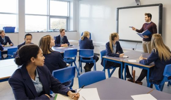 A high school classroom is pictured in the stock image above.