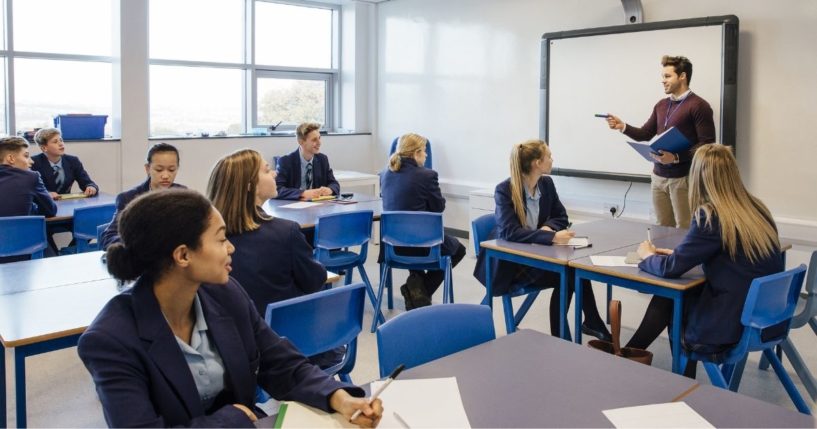 A high school classroom is pictured in the stock image above.