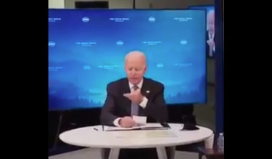 Upon being handed a note by one of his handlers during a Friday meeting, President Joe Biden wiped something off his chin and appeared to eat it.