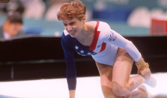 Kerri Strug of the United States grimaces after injuring her ankle while landing a vault during the team competition of the Women's Gymnastics event of the 1996 Summer Olympic Games held on July 23, 1996, in the Georgia Dome in Atlanta. Strug was part of the gold medal winning USA women's team, nicknamed "the Magnificent Seven."
