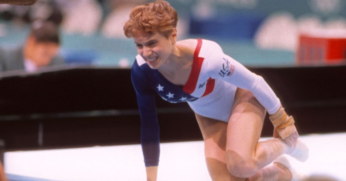 Kerri Strug of the United States grimaces after injuring her ankle while landing a vault during the team competition of the Women's Gymnastics event of the 1996 Summer Olympic Games held on July 23, 1996, in the Georgia Dome in Atlanta. Strug was part of the gold medal winning USA women's team, nicknamed "the Magnificent Seven."