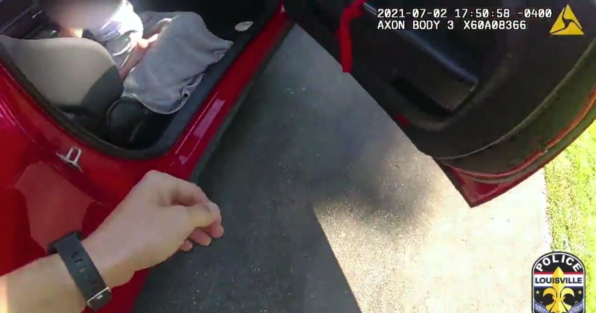 A police officer opens the door to rescue the 6-year-old girl who'd been kidnapped while riding her bike in Louisville, Kentucky, on July 2.