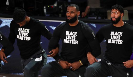 LeBron James of the Los Angeles Lakers, center, kneels with his teammates during the national anthem before a game against the Houston Rockets in during the 2020 NBA Playoffs at AdventHealth Arena on Sept. 4, 2020 in Lake Buena Vista, Florida.