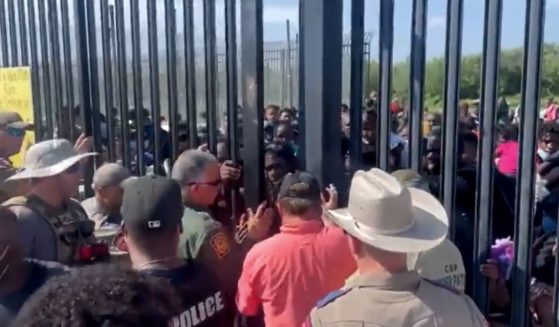 A group of more than 300 people tries to illegally enter the United States through a gate in Del Rio, Texas.