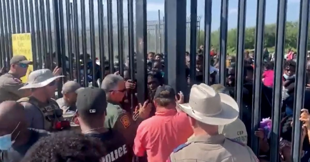 A group of more than 300 people tries to illegally enter the United States through a gate in Del Rio, Texas.