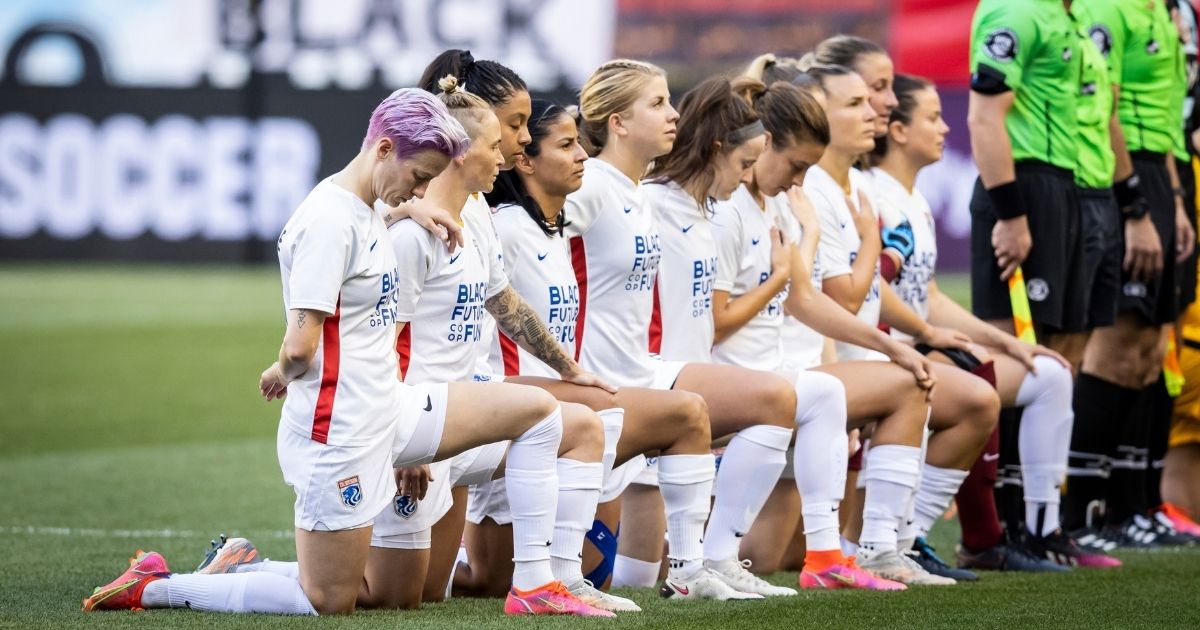 The starting lineup for the OL Reign, including Megan Rapinoe, left, kneel for the national anthem before the match against NJ/NY Gotham FC at Red Bull Arena on June 5, 2021, in Harrison, New Jersey.