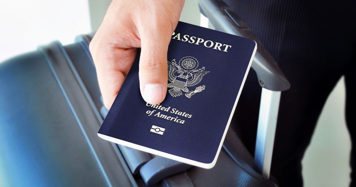 A man holding a passport is pictured in the stock image above.