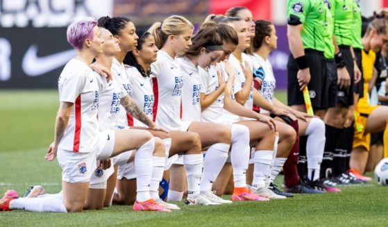 Megan Rapinoe, the face of the U.S. women's soccer team at the Tokyo Olympics, kneels during the national anthem alongside her teammates on the OL Reign before an NWSL match at Red Bull Arena in Harrison, New Jersey, on June 5.