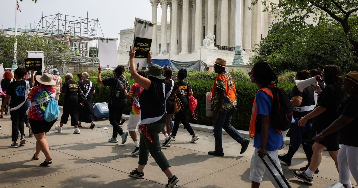 People arrive for the “Women’s Moral Monday March on Washington" rally organized by the Women’s March and Poor People Campaign in front of the U.S. Supreme Court on Monday in Washington, D.C.