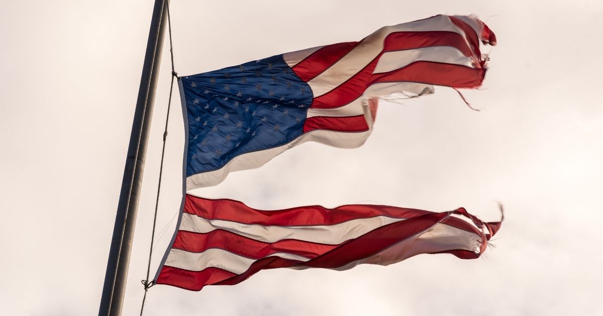 An American flag torn in half is pictured in the stock image above.