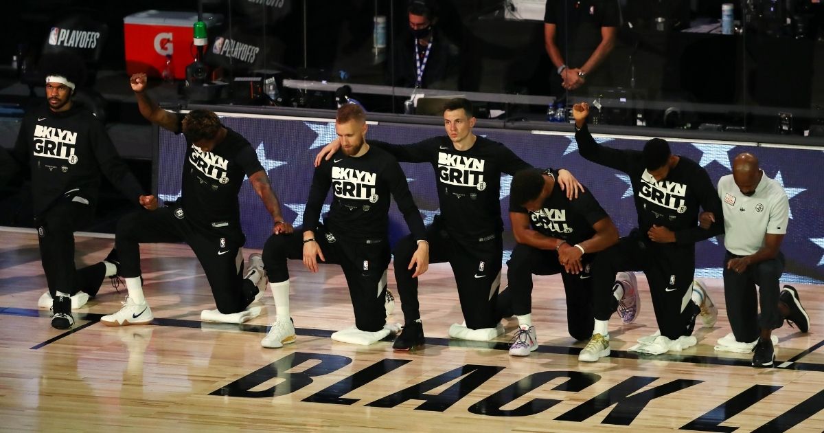 Brooklyn Nets players kneel for the national anthem before action against the Toronto Raptors in game four of the first round of the NBA playoffs at The Field House at ESPN Wide World Of Sports Complex on Aug. 23, 2020, in Lake Buena Vista, Florida.