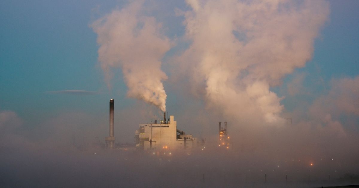 Pollution from a paper mill in Tacoma, Washington, pours into the air at dusk.