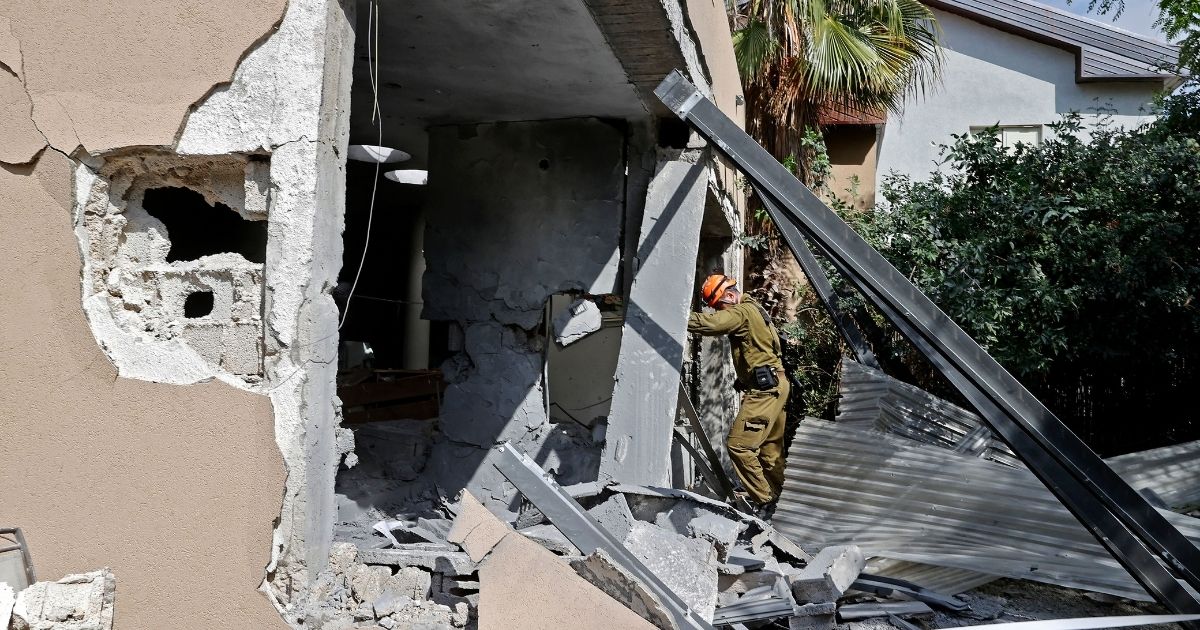A member of an Israeli rescue team inspects a house hit by a rocket fired from the Gaza Strip on May 20, 2021. Israel and the Palestinians are mired in their worst conflict in years.