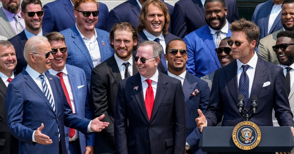 President Joe Biden gestures as Tampa Bay Buccaneers quarterback Tom Brady jokes Tuesday at the White House.