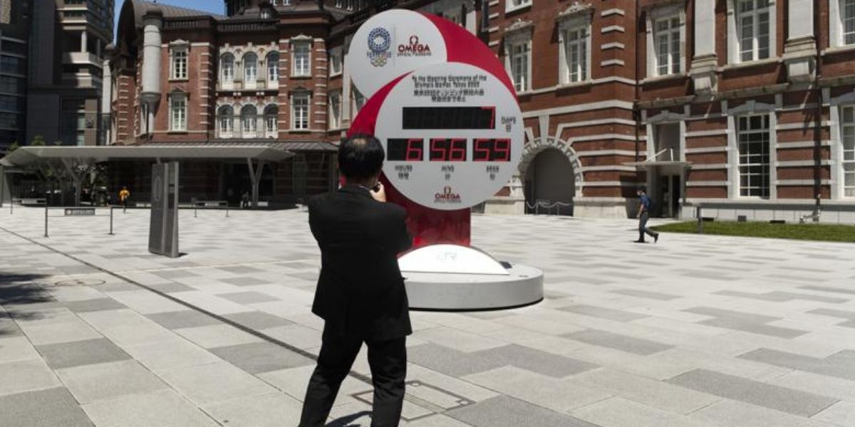 A man takes a picture of a countdown clock that shows seven more days to go before the opening ceremony of the Olympic Games in Tokyo on Friday.