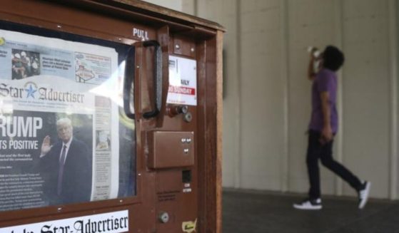 A man walks past a newspaper stand at the international airport in Honolulu on Friday, Oct. 2, 2020. The coronavirus pandemic expanded news audiences for many newspapers and TV news channels, making 2020 a blockbuster news year.