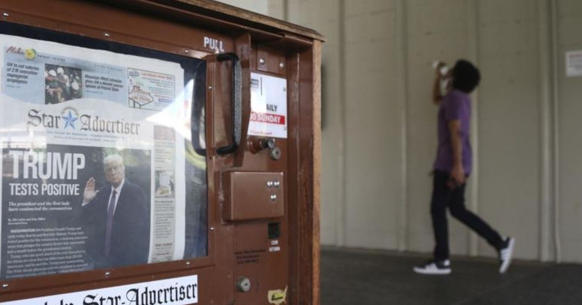 A man walks past a newspaper stand at the international airport in Honolulu on Friday, Oct. 2, 2020. The coronavirus pandemic expanded news audiences for many newspapers and TV news channels, making 2020 a blockbuster news year.