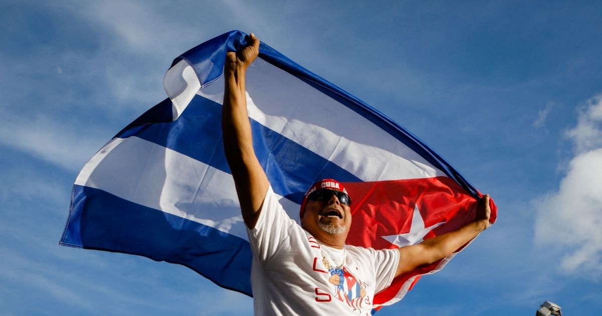 A man holds a Cuban flag Sunday during a demonstration showing support for Cubans protesting against their government, at Versailles Restaurant in Miami.
