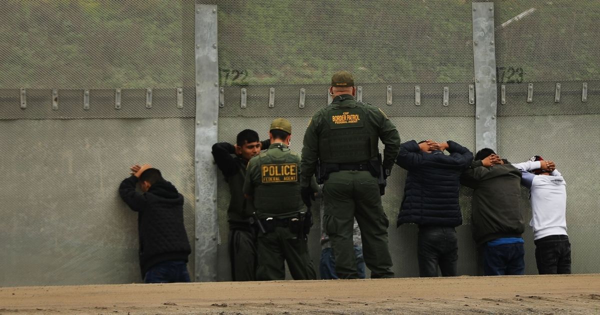 Men surrender to U.S. Border Patrol agents after jumping a fence in an attempt to get into the United States from Tijuana, Mexico, on Jan. 17, 2019.