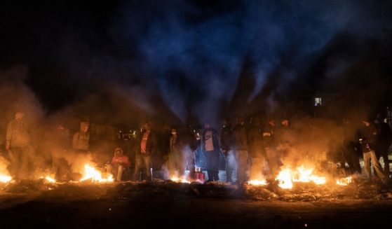 Armed community members gather around a fire to keep warm at a roadblock set up in Phoenix Township, North Durban, on Thursday to prevent looters from reaching the community.