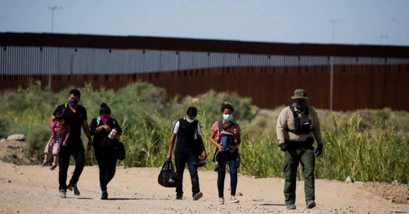 Migrants from Guatemala follow an officer after illegally crossing the border between the United States and Mexico into Yuma, Arizona, on May 12.