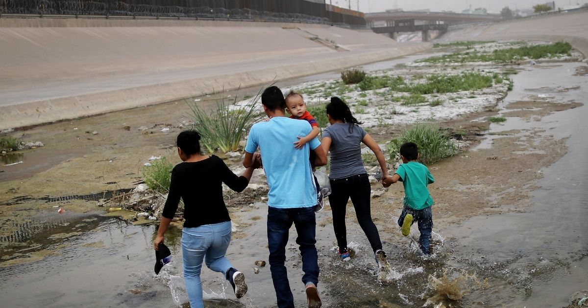 Migrants hold hands as they cross the border between the U.S. and Mexico at the Rio Grande river, on their way to enter El Paso, Texas, on May 20, 2019.