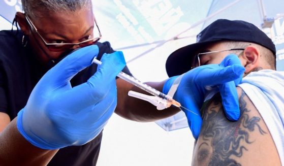 Nurse Eon Walk, left, administers the Pfizer-BioNTech COVID-19 vaccine at a mobile vaccine clinic hosted by Mothers in Action and operated by the Los Angeles County of Public Health on July 16, 2021, in Los Angeles.