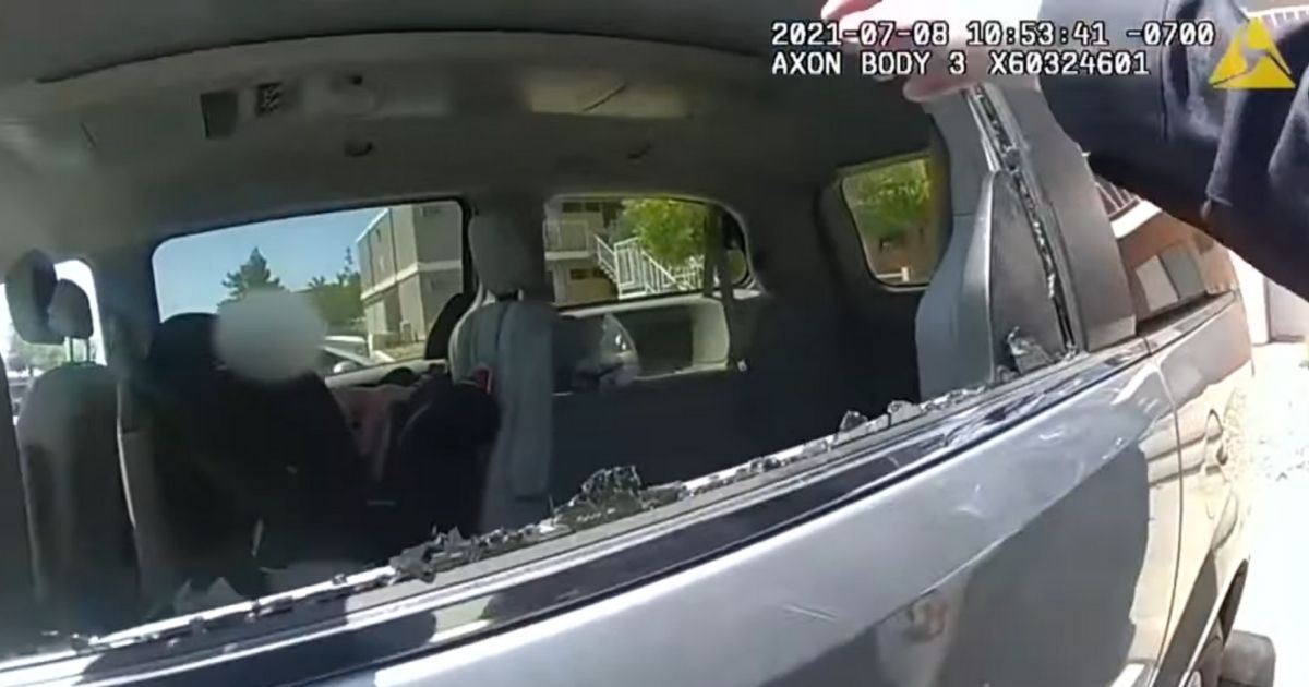 A police officer is seen breaking a car's window to rescue the 2-year-old who became trapped inside when his mother accidentally locked the keys in her car.