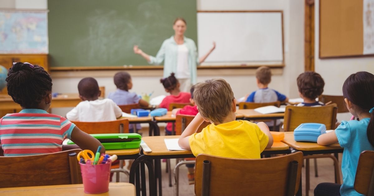 Children sit in a classroom in this stock image.