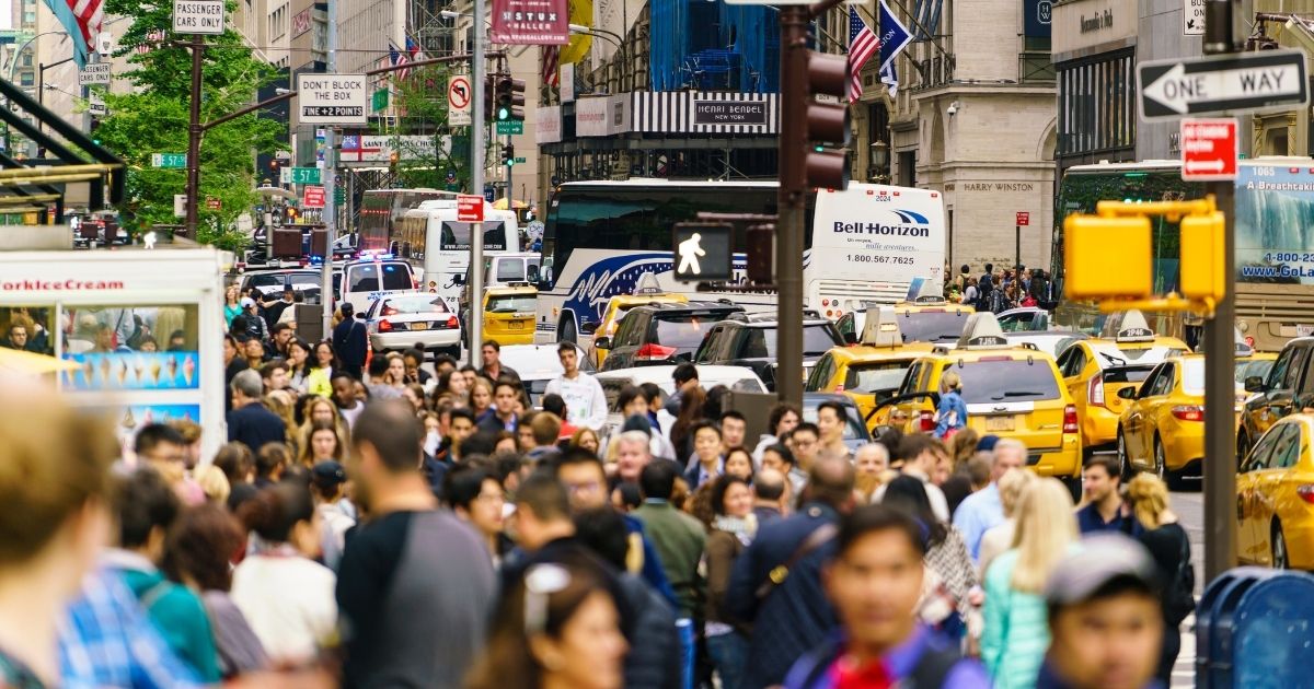 This stock image shows a crowded city sidewalk.