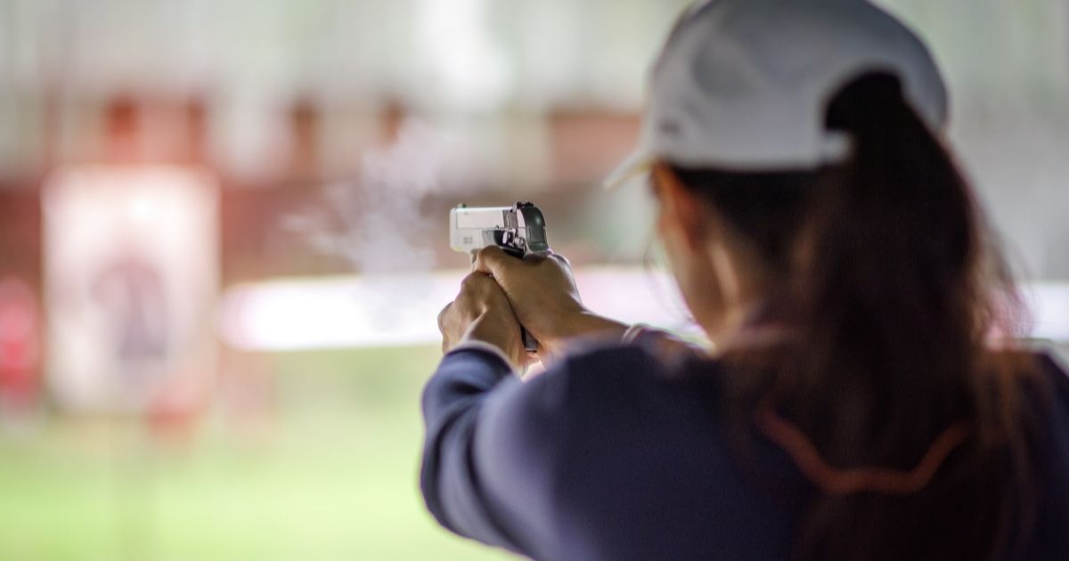 A woman fires a gun in the above stock image.