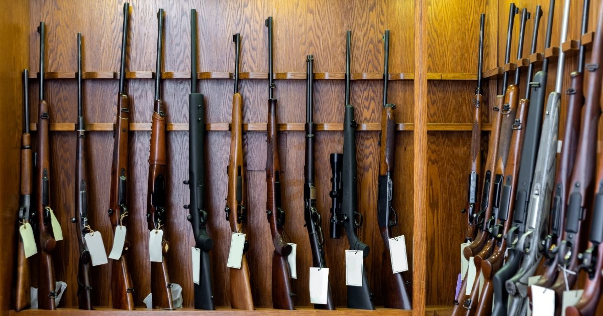 Guns are displayed in a store in this stock image.