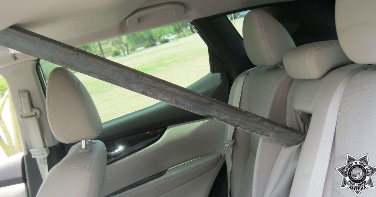 A 4-foot-long metal pole fell off the back of a trailer and flew through the window of the SUV behind, narrowly missing the driver.