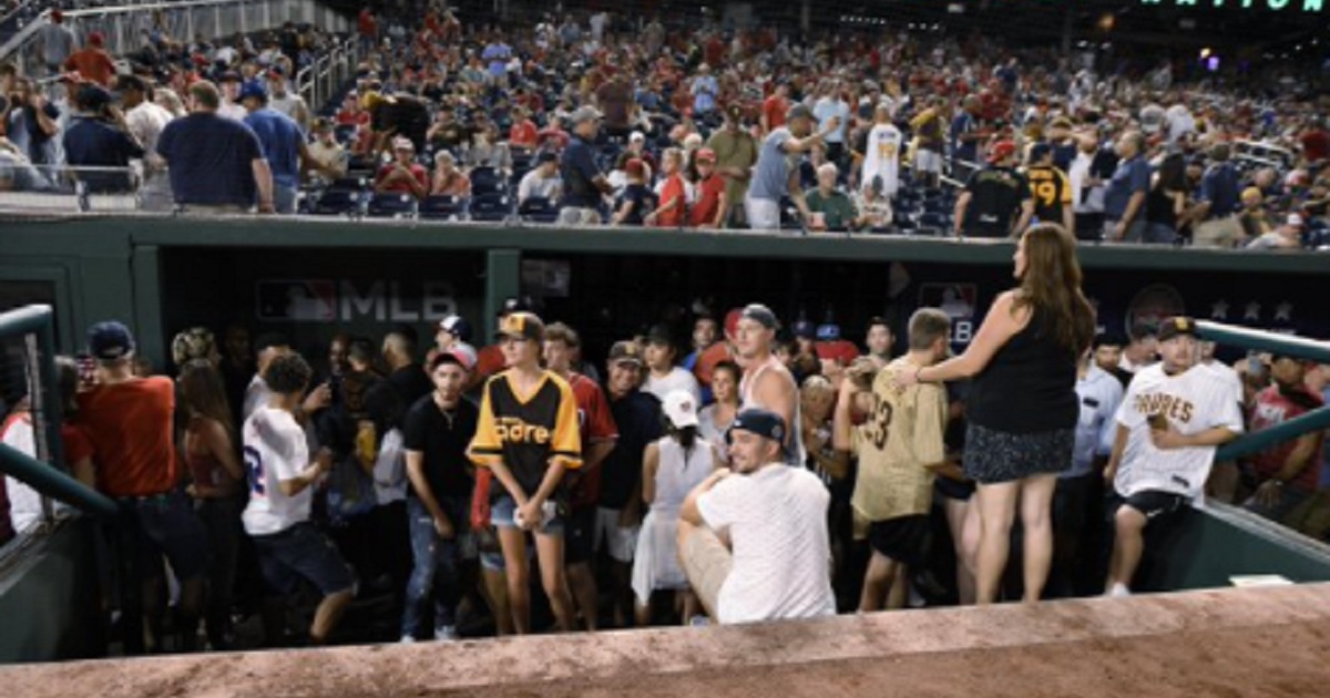 Fans gather in a dugout Saturday after a game at Nationals Park in Washington was halted by an incident of gunfire outside the stadium.
