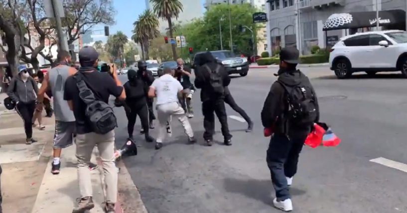 Antifa thugs assault a man wearing a "Trust Jesus" T-shirt Saturday during violence in Los Angeles.