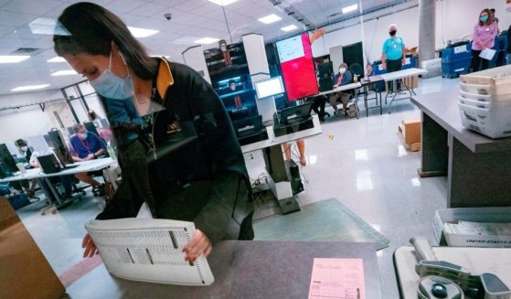 A poll worker sorts ballots inside the Maricopa County Election Department in Phoenix on Nov. 5, 2020.