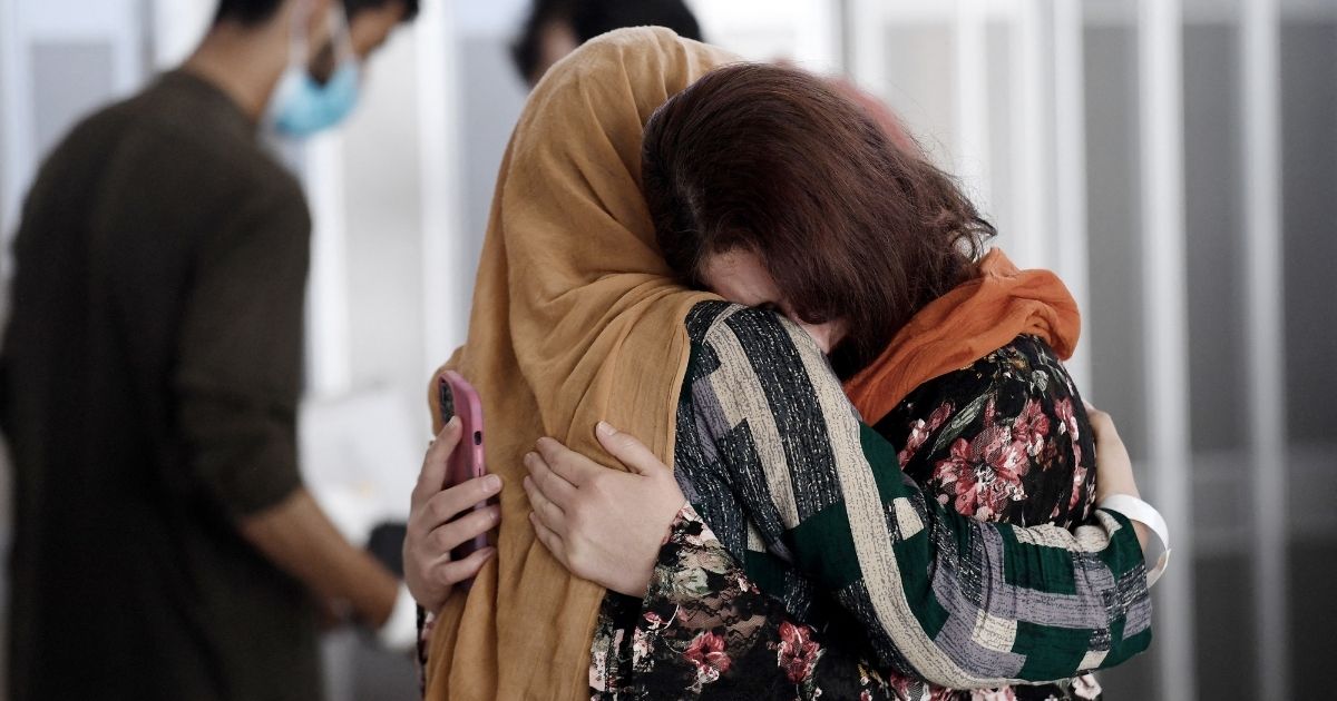 A woman embraces her sister-in-law as she arrives with other Afghan refugees on a flight at Dulles International Airport in Chantilly, Virginia, on Monday.