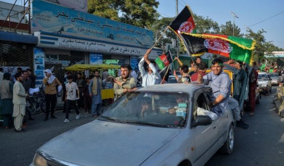 People carry Afghanistan's national flag on the 102th Independence Day of the country in the Wazi Akbar khan area of Kabul on Thursday amid the Taliban's military takeover of Afghanistan.